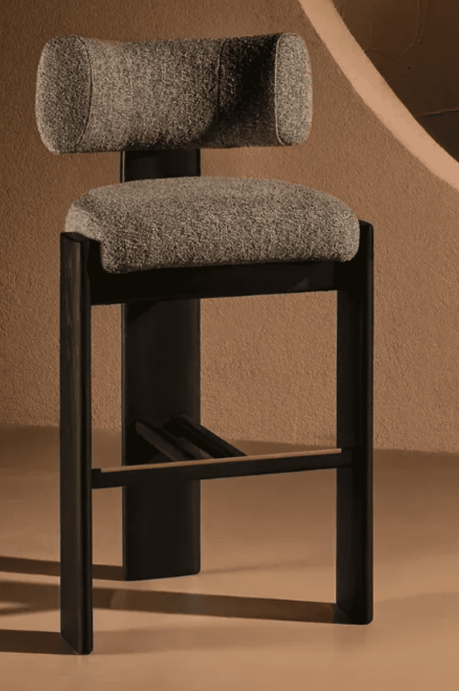 A modern bar stool featuring a curved backrest and seat upholstered in a textured grey fabric. The b… — 3D model