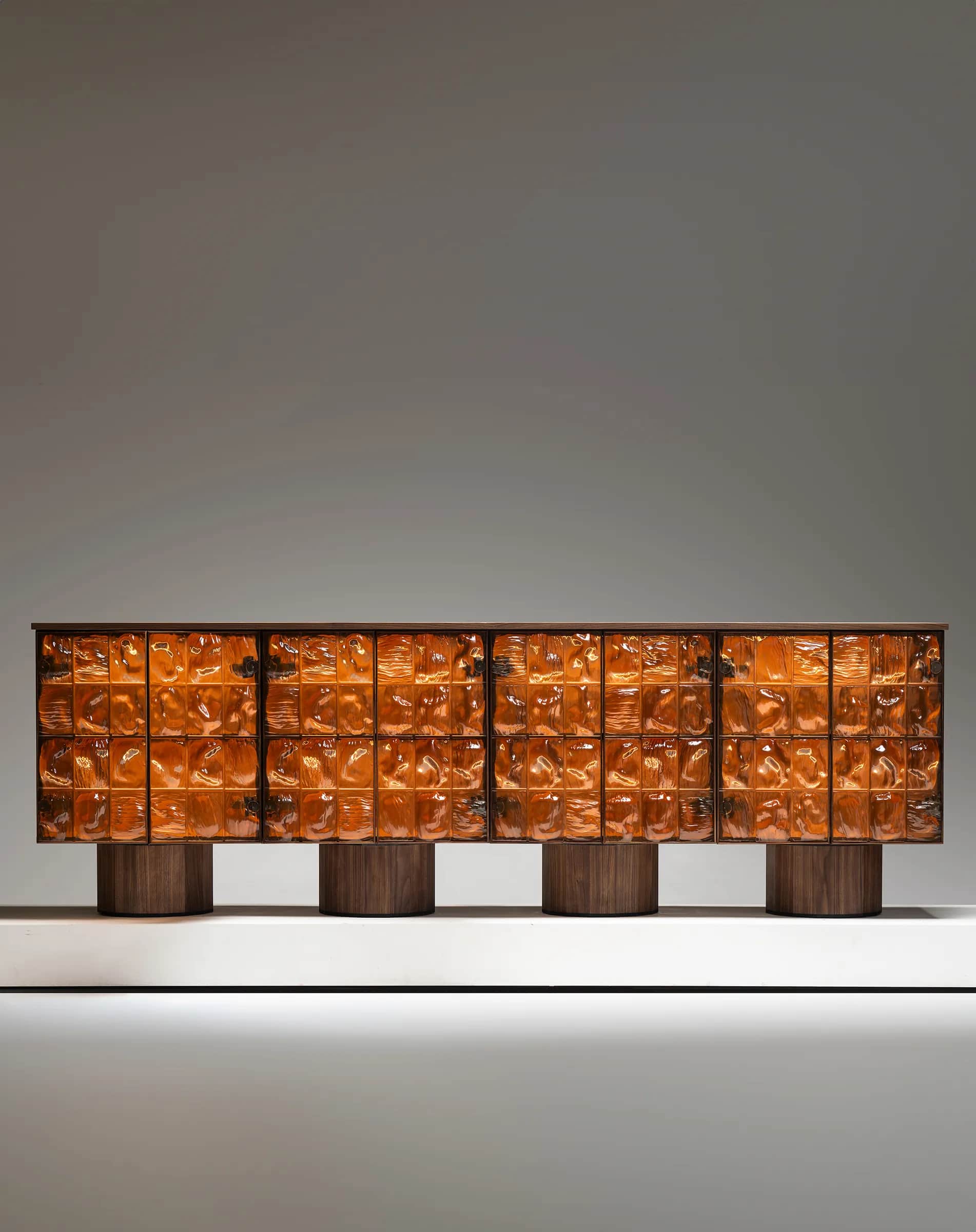 A long, low cabinet with a dark wood frame. The front of the cabinet is composed of multiple rows an… — 3D model
