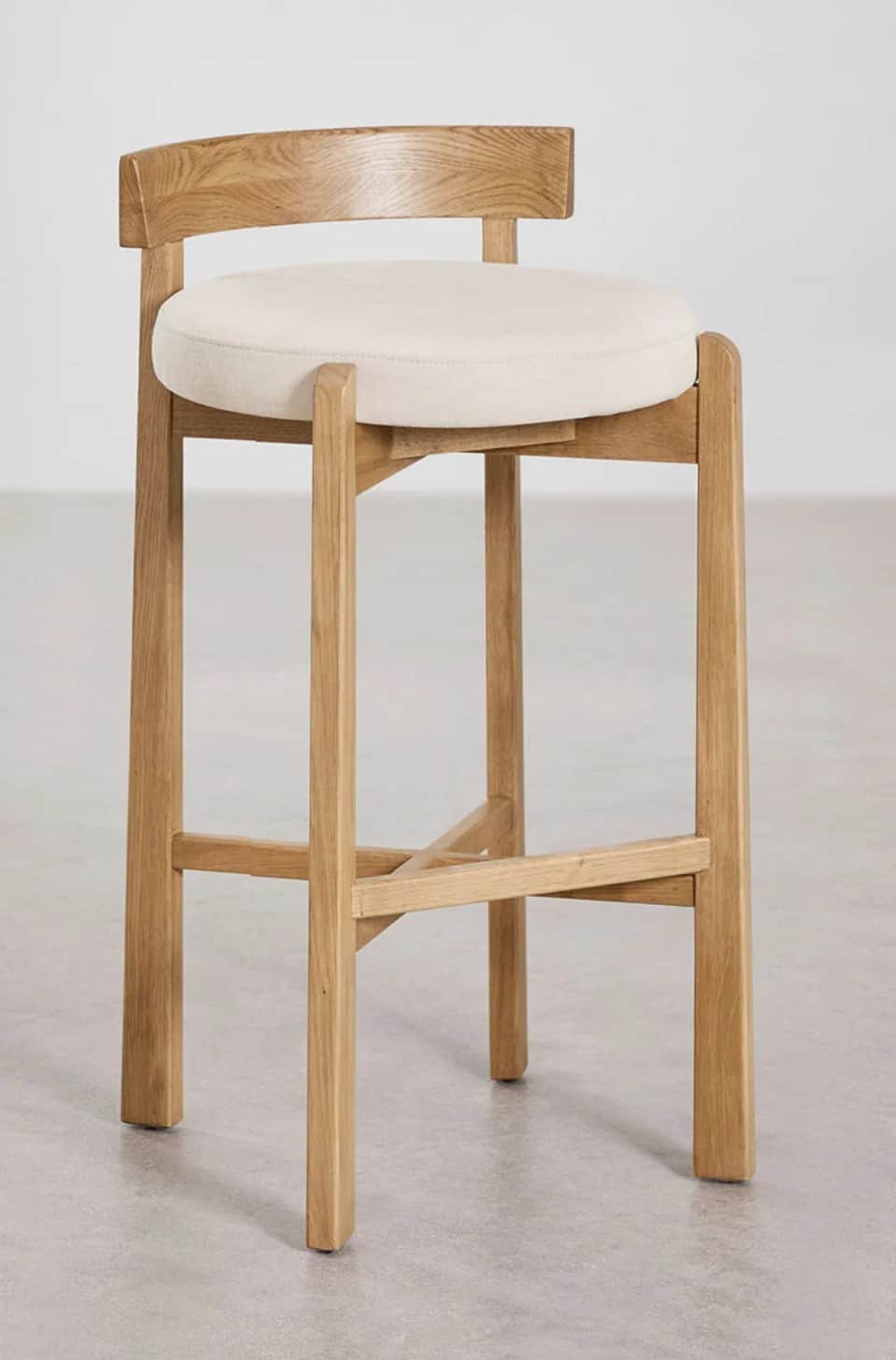 A wooden bar stool with a cushioned seat and a curved backrest. The stool has four legs connected by… — 3D model
