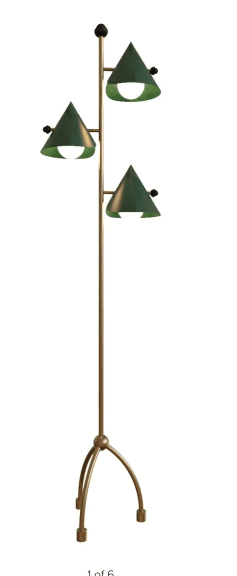 A tall, slender floor lamp featuring a brass-toned metallic pole and a three-legged, arched tripod b… — 3D model