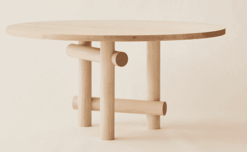 A round dining table with a light wood finish. The table features a flat, circular top and a unique… — 3D model