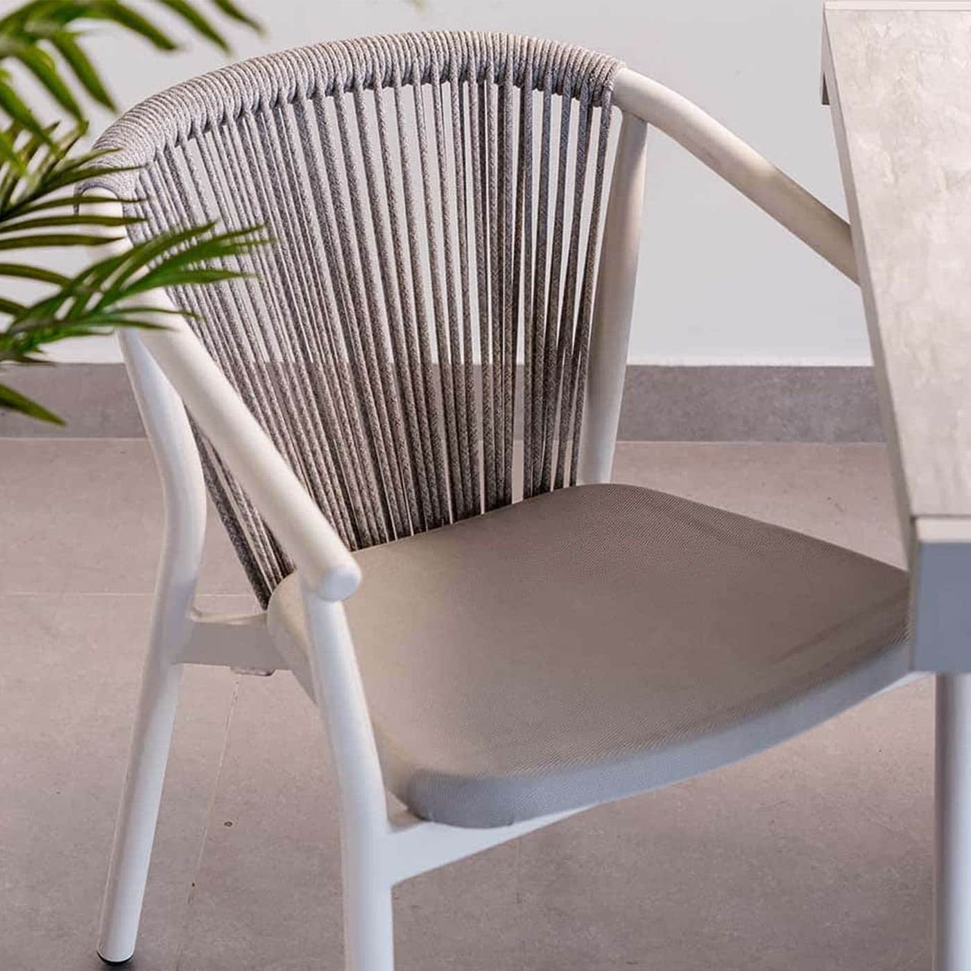 A modern armchair with a white frame and a woven rope backrest. It features a cushioned seat in a li… — 3D model