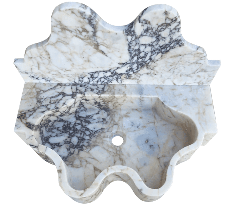 A wall-mounted sink carved from a single piece of marble. It features an intricately shaped basin wi… — 3D model