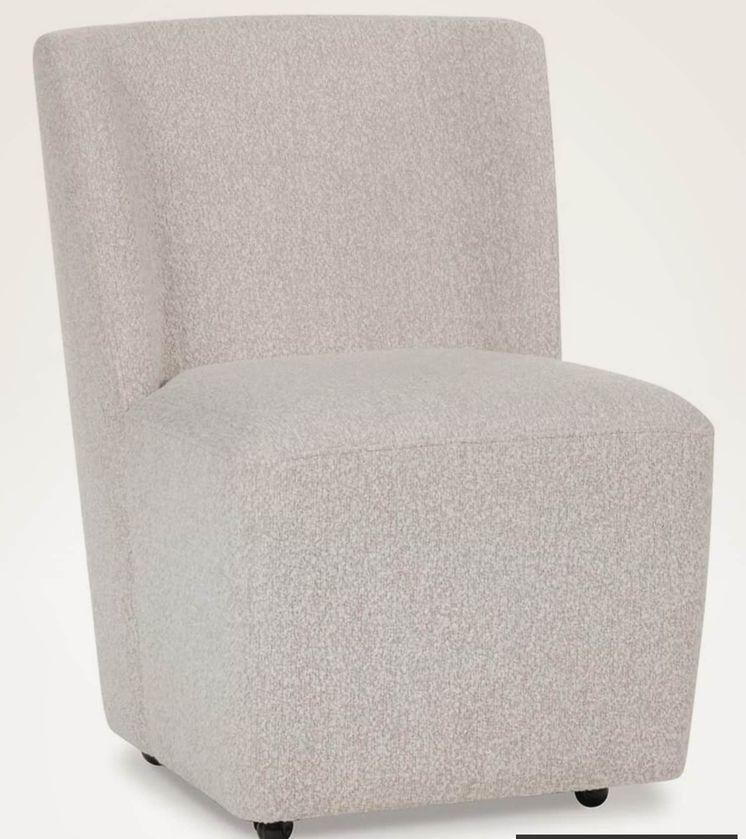 A fully upholstered armless accent chair featuring a light beige, textured boucle fabric. The chair… — 3D model