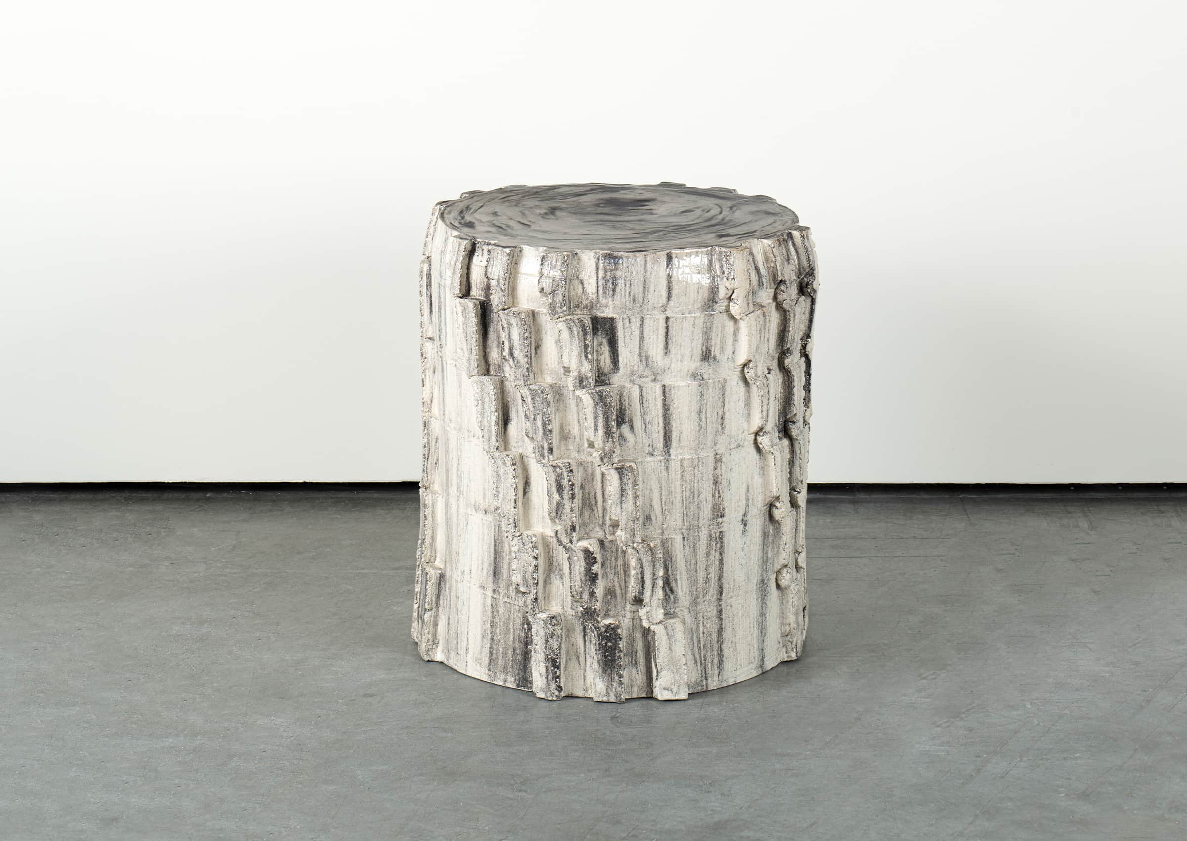 A cylindrical side table with a textured surface resembling tree bark. The top surface has a marbled… — 3D model