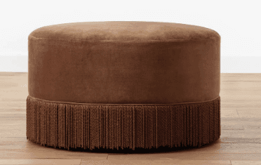 A contemporary round ottoman featuring plush velvet upholstery and a decorative fringe trim around i… — 3D model