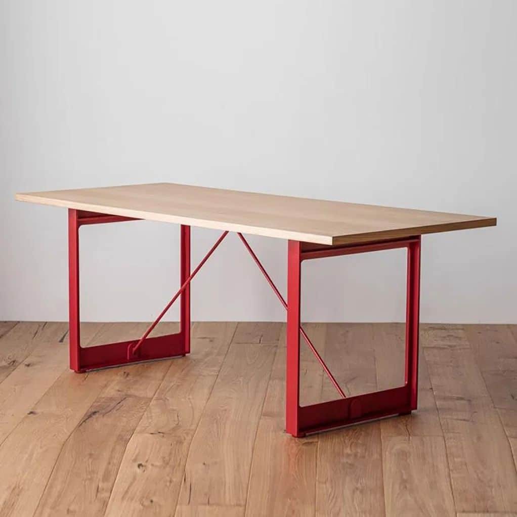 A modern rectangular table featuring a light wood tabletop and two striking red metal trestle bases.… — free BLEND 3D model