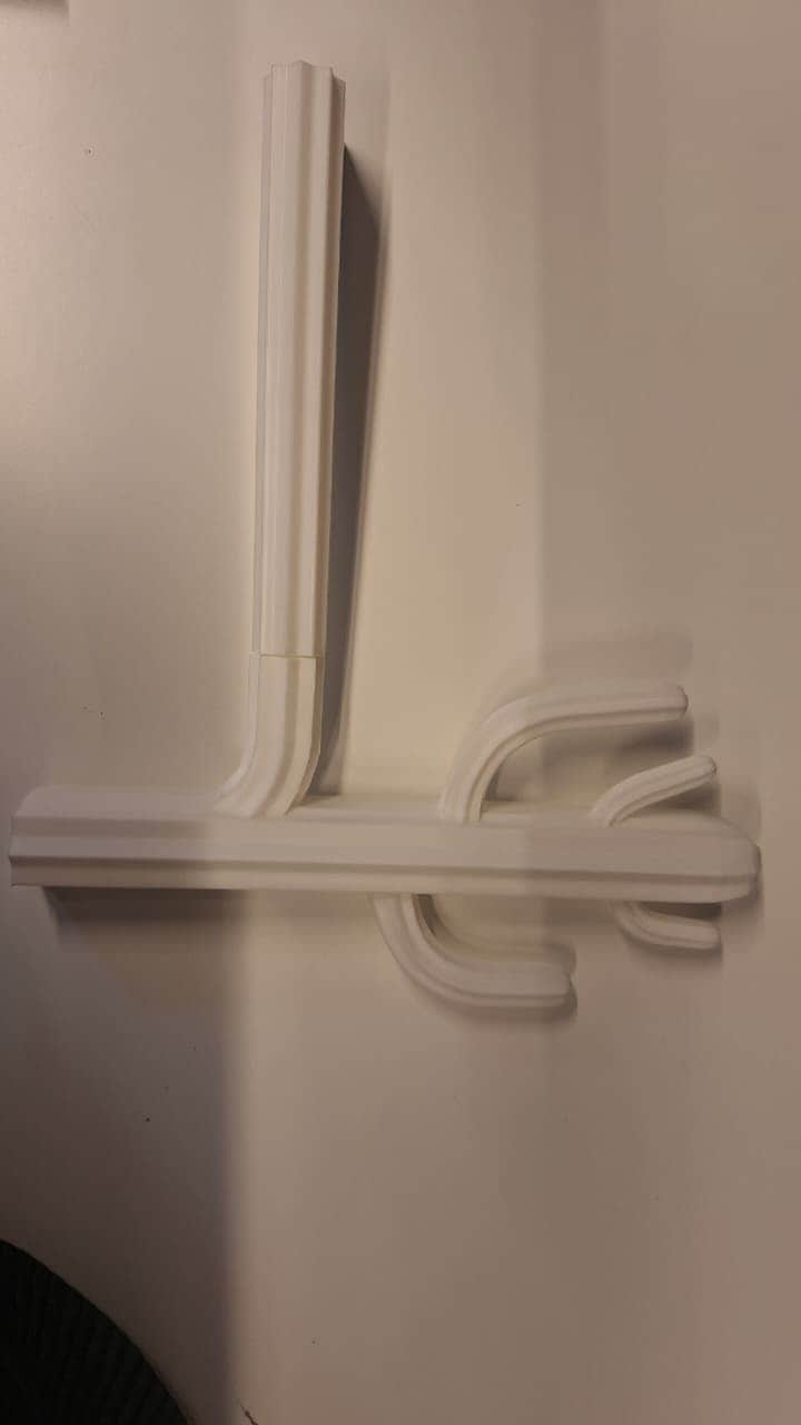 A minimalist, wall-mounted coat rack rendered in a uniform white finish. It features a vertical rect… — free BLEND 3D model