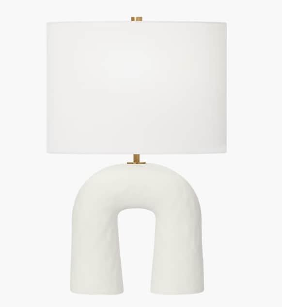 A modern table lamp featuring a distinctive arch-shaped ceramic base and a classic cylindrical fabri… — 3D model