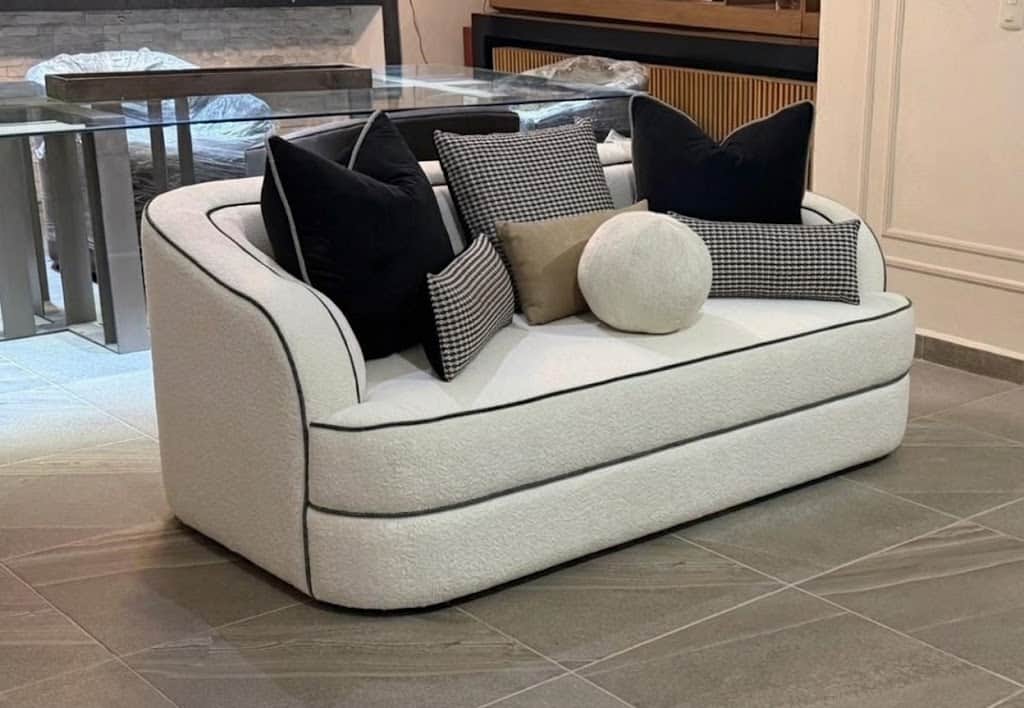 A compact, contemporary loveseat upholstered in an off-white bouclé fabric, featuring distinctive bl… — 3D model