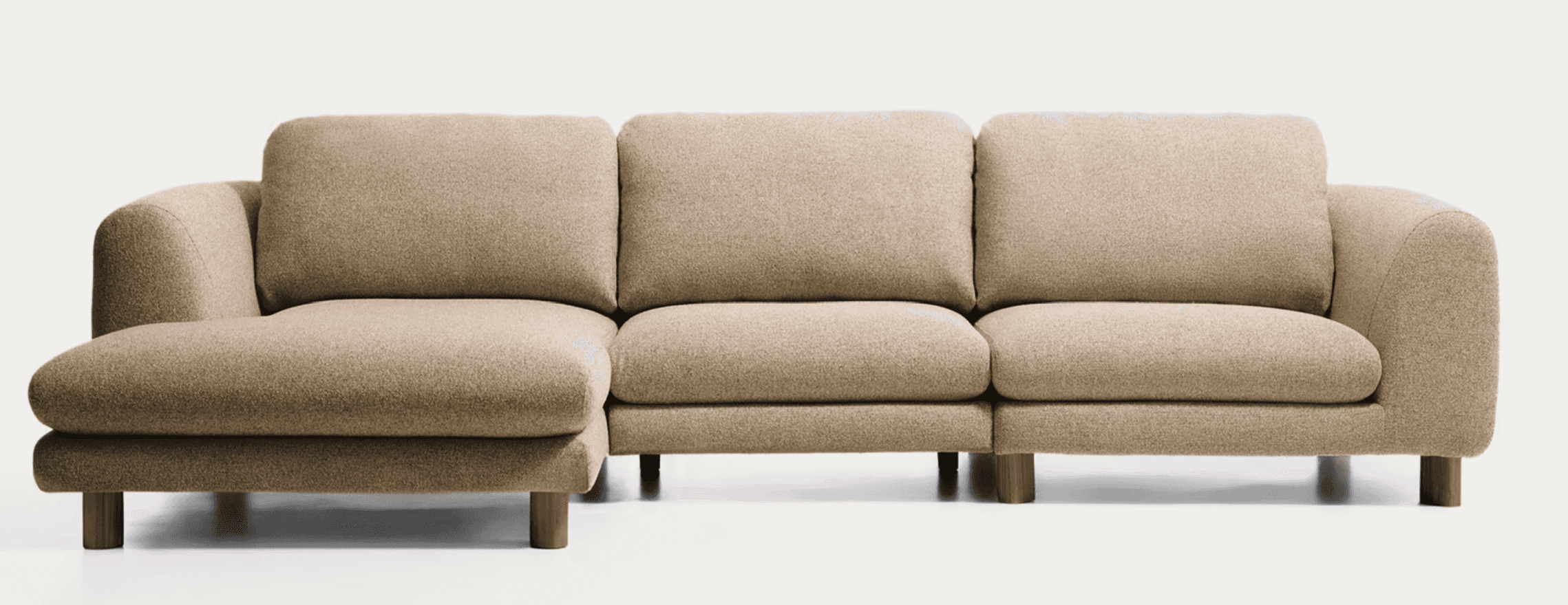 A beige upholstered modular sectional sofa featuring an integrated left-hand chaise lounge and two a… — 3D model