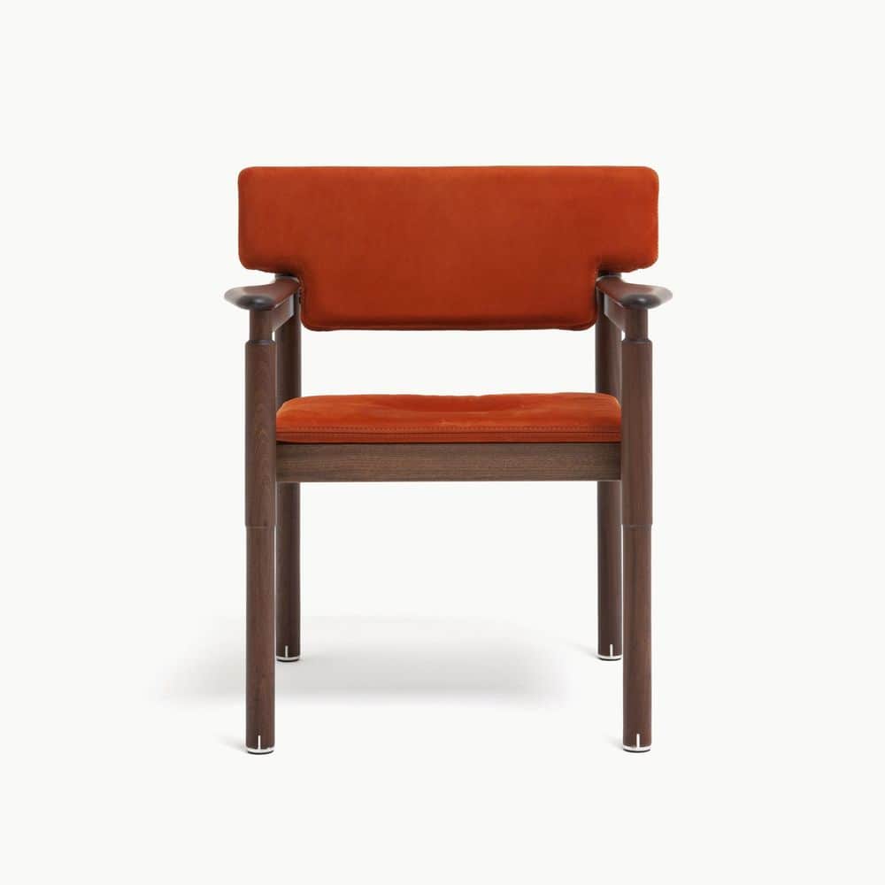 A contemporary armchair featuring a dark wood frame and rust-colored upholstered seat and backrest.… — 3D model