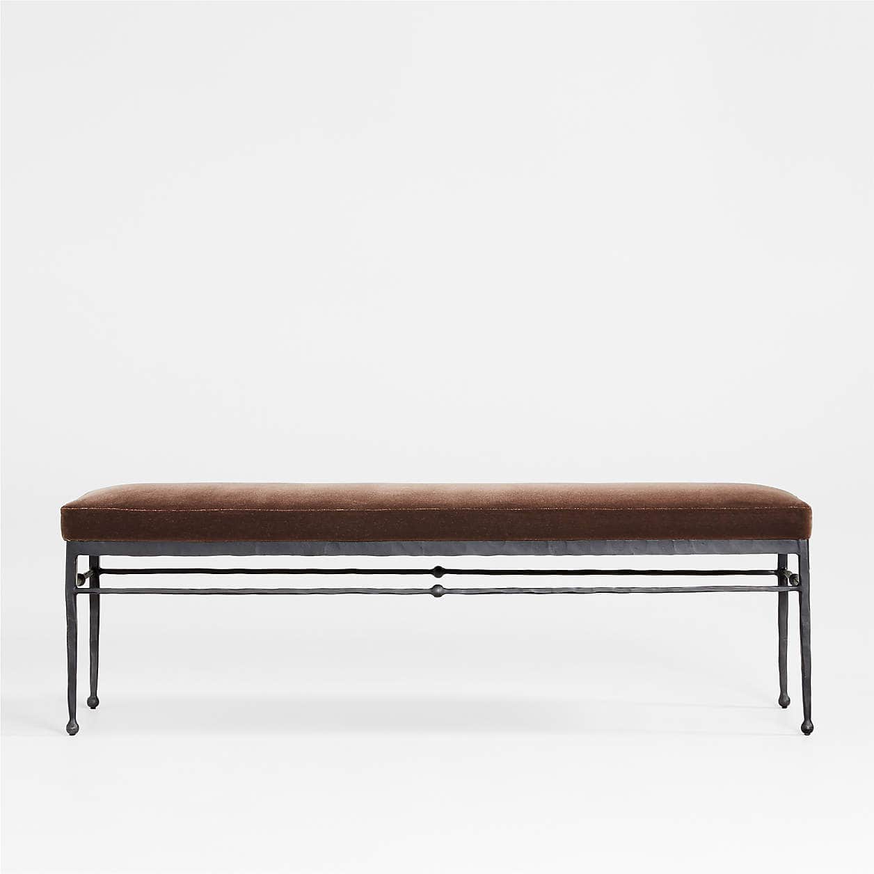 A long, rectangular bench featuring a plush, brown velvet upholstered cushion atop a dark, hammered… — 3D model