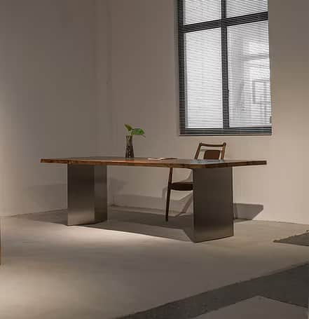 A contemporary dining table featuring a live-edge wooden tabletop and two solid, rectangular metal b… — 3D model