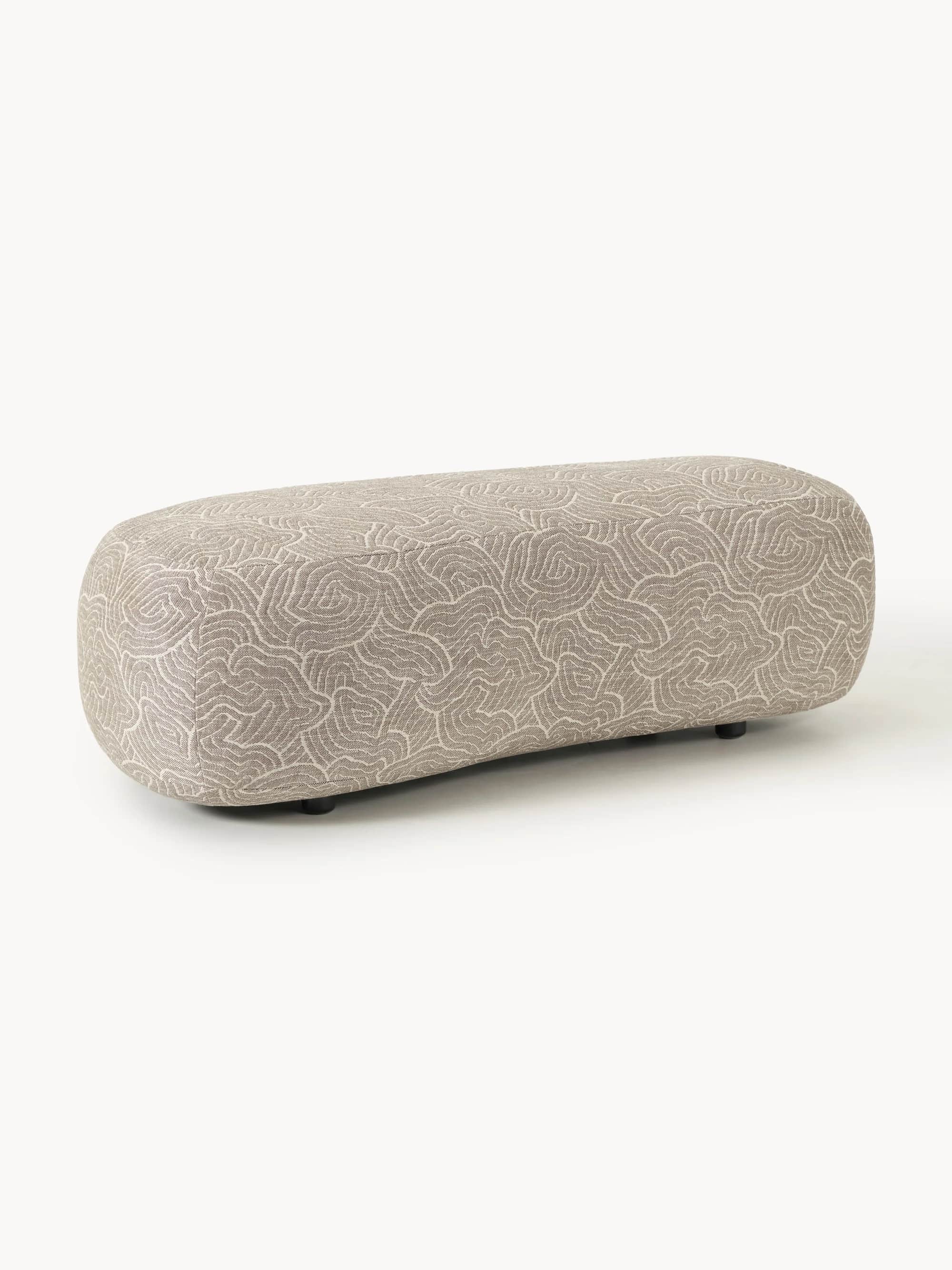 An oblong-shaped ottoman with rounded edges, upholstered in a fabric featuring a repeating organic,… — 3D model