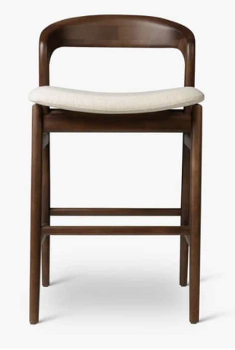 A wooden bar stool with a curved backrest and a cushioned seat. The stool features four tapered legs… — 3D model