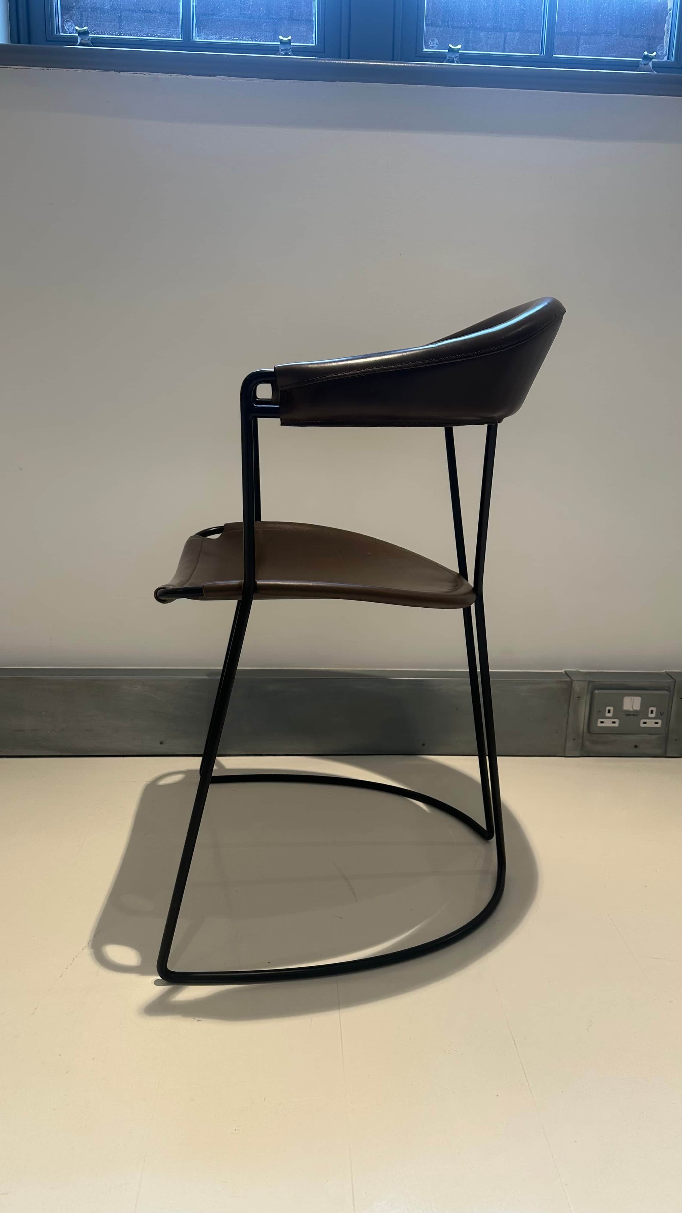 A contemporary armchair with a dark brown leather seat and backrest supported by a slender black met… — 3D model