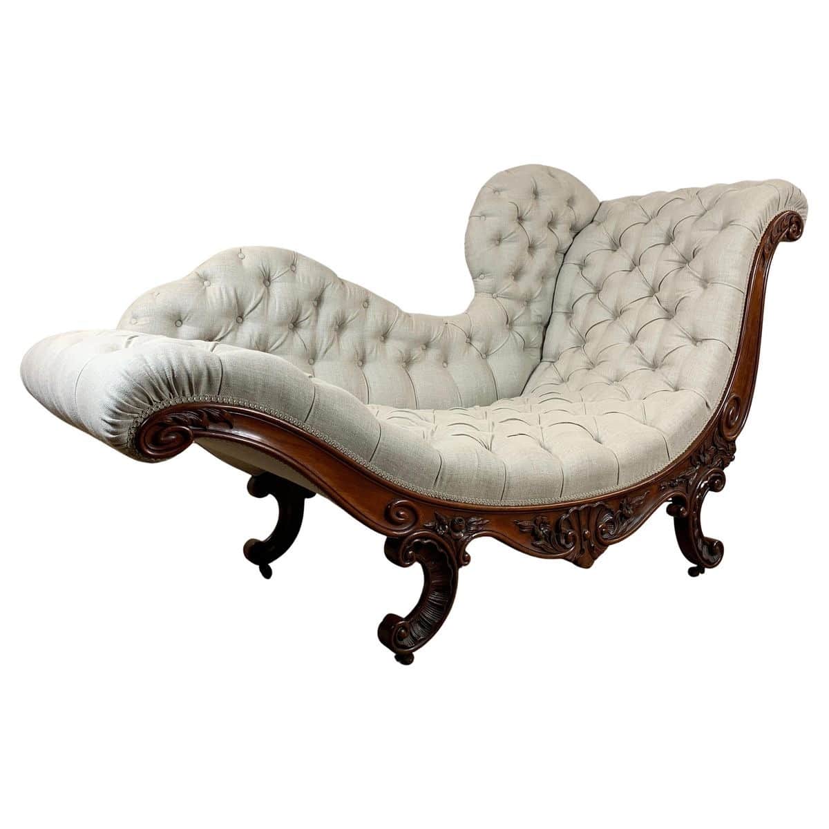 An ornate chaise lounge featuring a dark, elaborately carved wooden frame and light-colored button-t… — 3D model