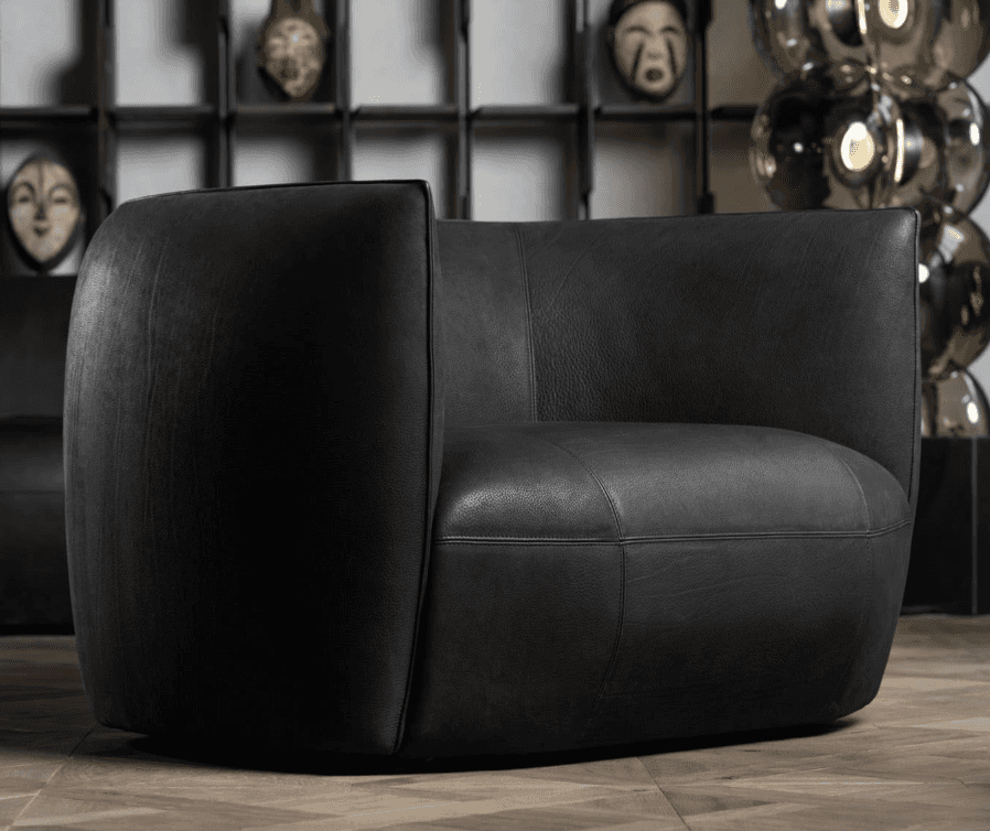A contemporary barrel-shaped armchair upholstered in black leather, featuring a seamless design with… — 3D model