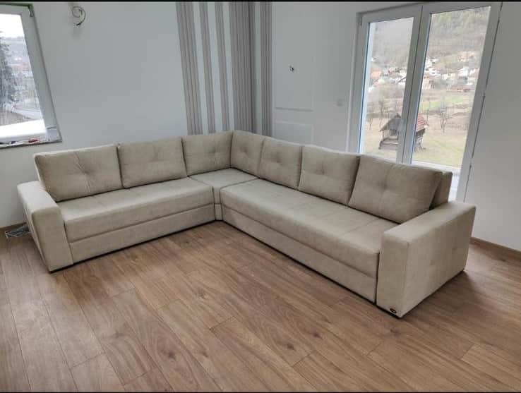 A large, modern L-shaped sectional sofa upholstered in a light beige or cream-colored fabric. The so… — 3D model