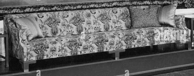 A long upholstered sofa with a floral pattern fabric covering its cushions, backrest, and frame. It… — free GLTF 3D model