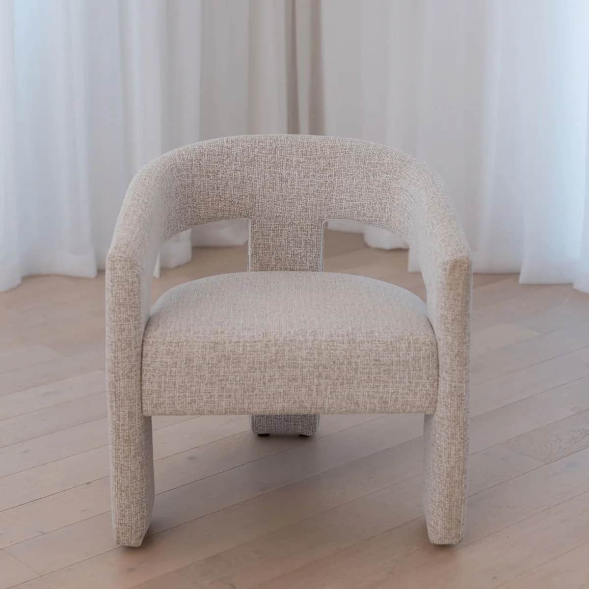 A modern upholstered armchair with a curved back and straight arms. The chair features a textured fa… — 3D model