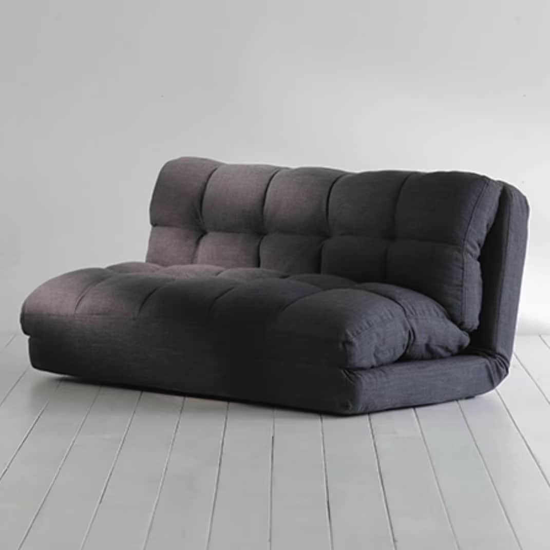 A contemporary, floor-level futon sofa designed for versatility and comfort, upholstered in a dark g… — 3D model