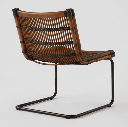 An armless lounge chair featuring a natural rattan or cane seat and backrest with a tubular black me… — 3D model