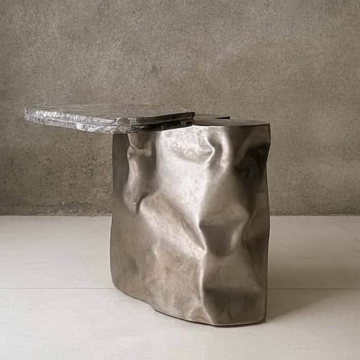 A unique accent table featuring a heavily textured, crumpled cast metal base and an irregularly shap… — 3D model