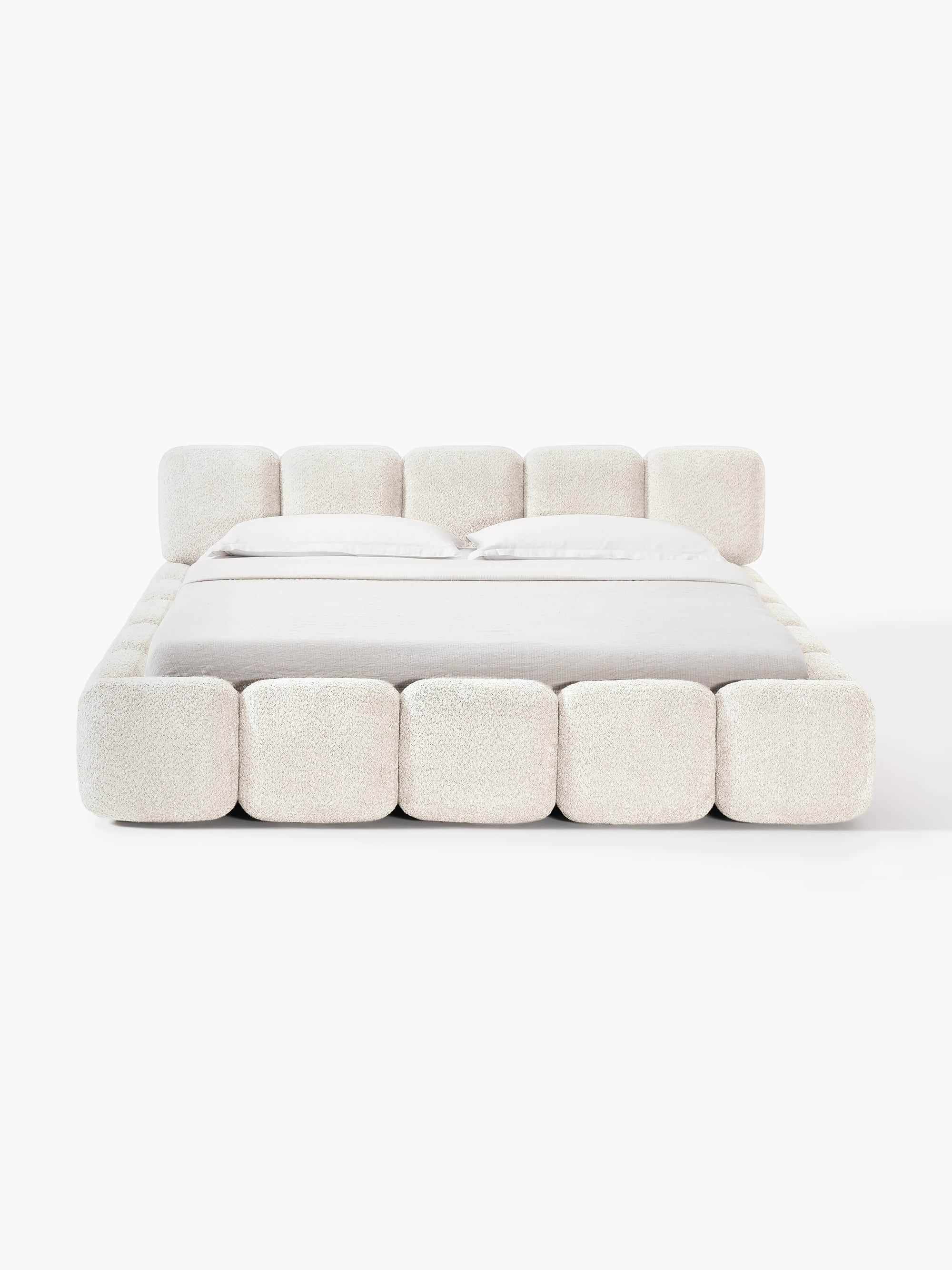 A plush, upholstered bed frame with a tufted headboard and footboard. The bed is dressed with white… — free FBX 3D model
