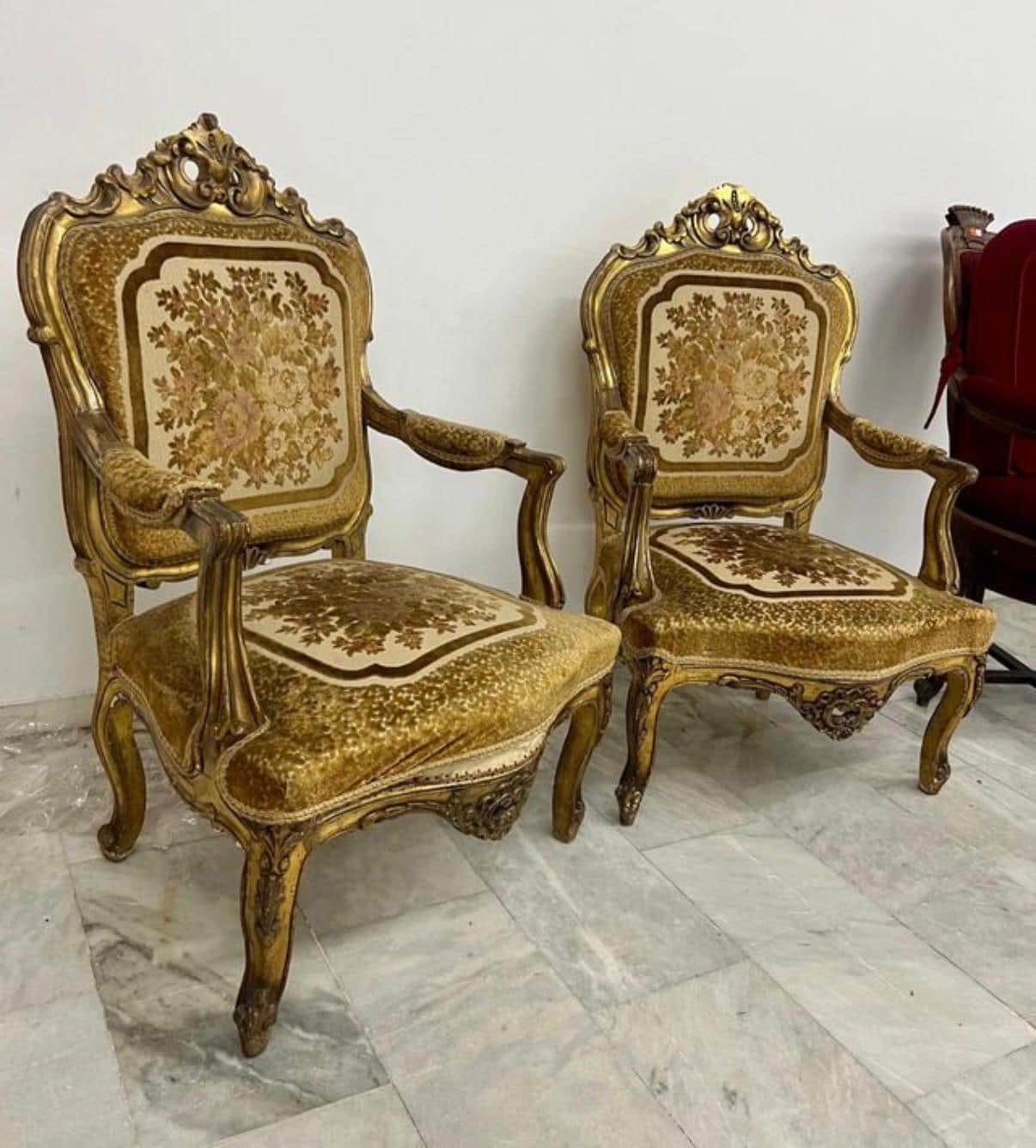 A highly ornate, antique-style armchair featuring a gilded wooden frame with elaborate carvings and… — 3D model