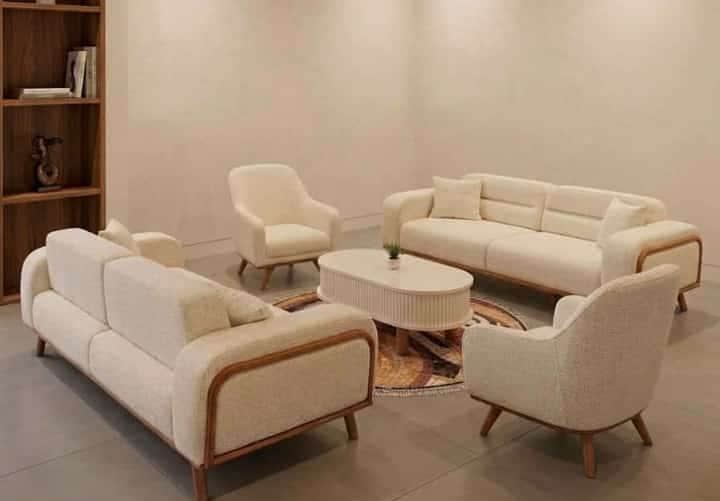 An oval-shaped modern coffee table featuring a white fluted body and natural wood splayed legs. — free BLEND 3D model