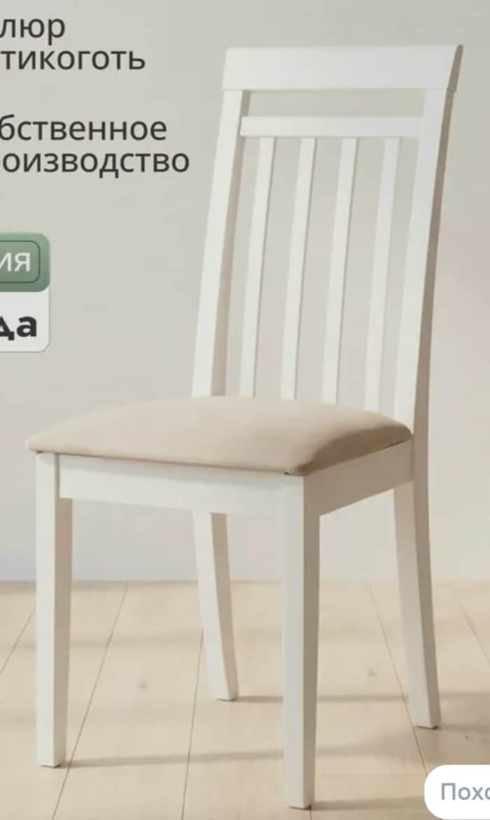 A white wooden dining chair featuring a slatted backrest and a light beige upholstered seat cushion,… — 3D model