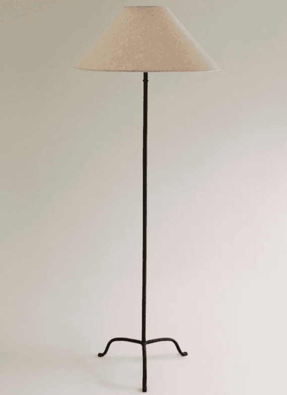 A tall, slender floor lamp featuring a dark, possibly wrought iron, stem that branches into a three-… — 3D model
