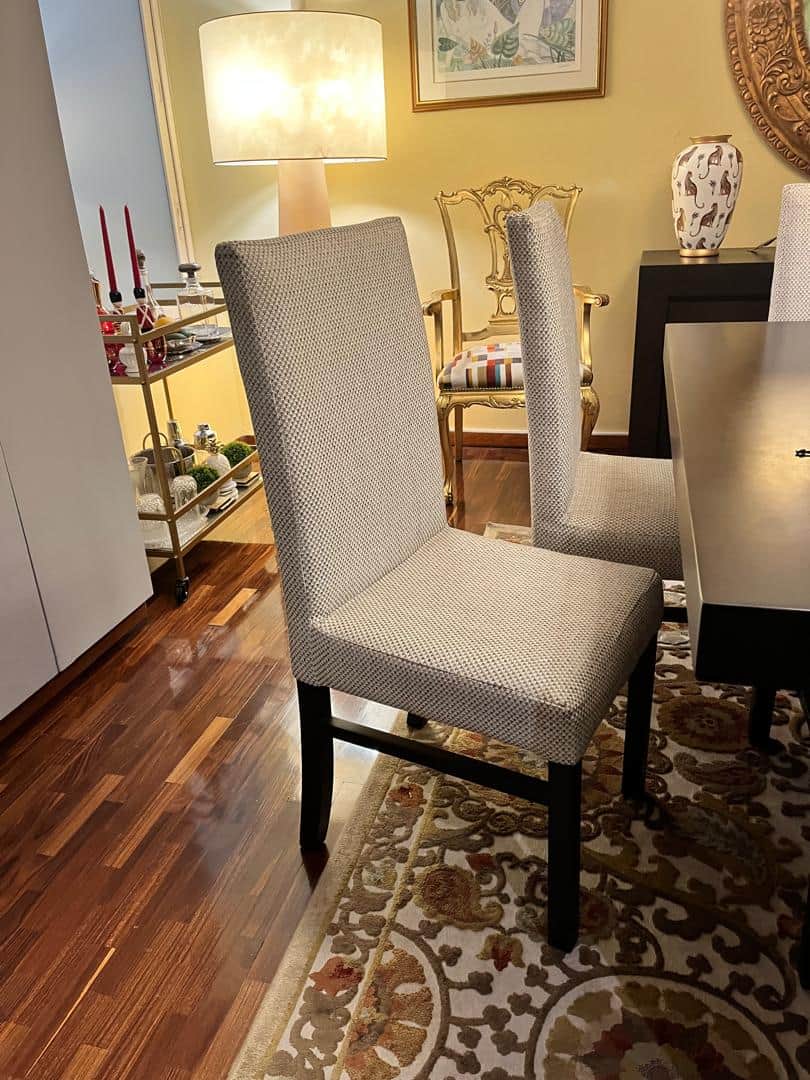 A contemporary upholstered dining chair featuring a light-colored, textured fabric covering both the… — 3D model