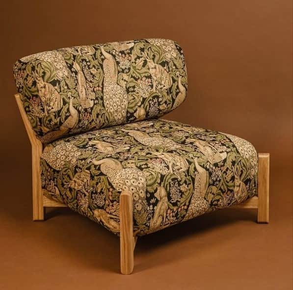 An armless lounge chair with a low-profile design, featuring a sturdy light wood frame and plush uph… — 3D model