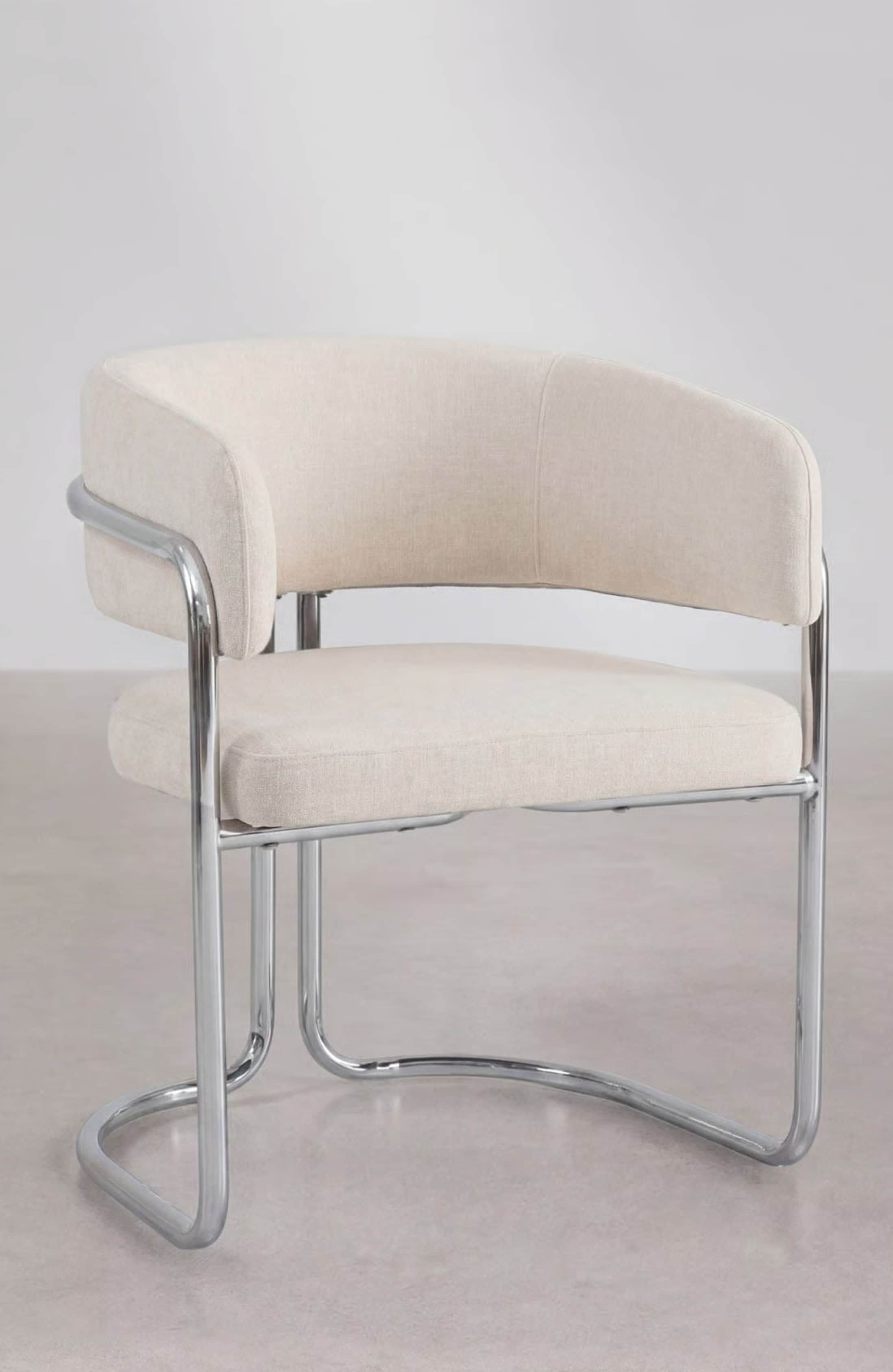 A modern armchair featuring a tubular chrome frame and upholstered in a light, neutral fabric. The s… — 3D model
