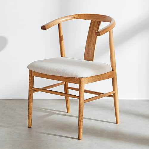 A modern armchair constructed from light-toned solid wood, featuring a distinctive curved yoke-shape… — free STL 3D model