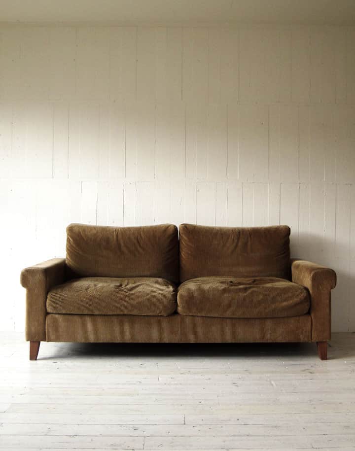 A two-seater sofa with a brown textured upholstery. The sofa features rolled arms, plush seat and ba… — free GLTF 3D model