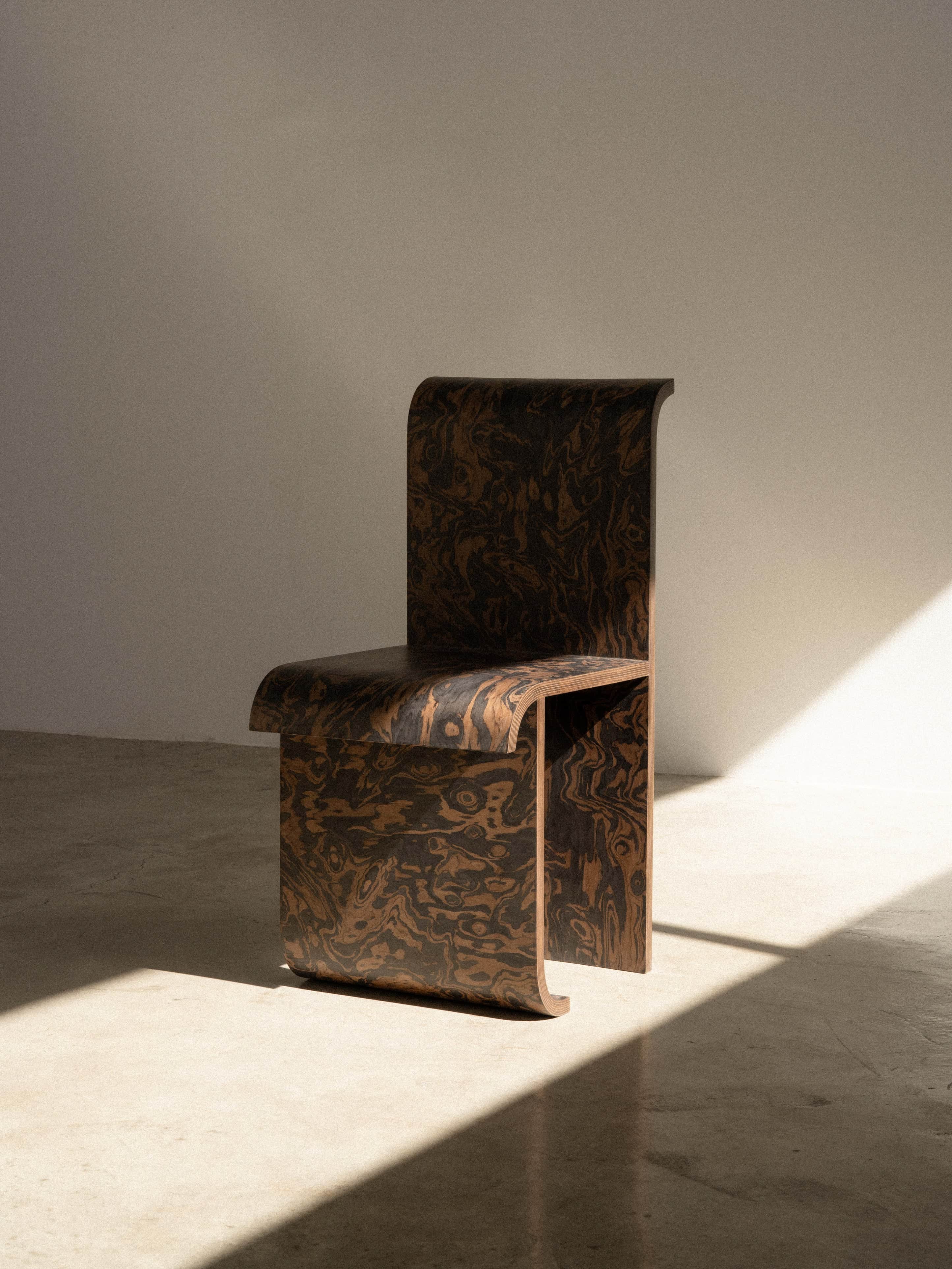 A minimalist, armless side chair constructed from a single piece of bent plywood, featuring a distin… — 3D model
