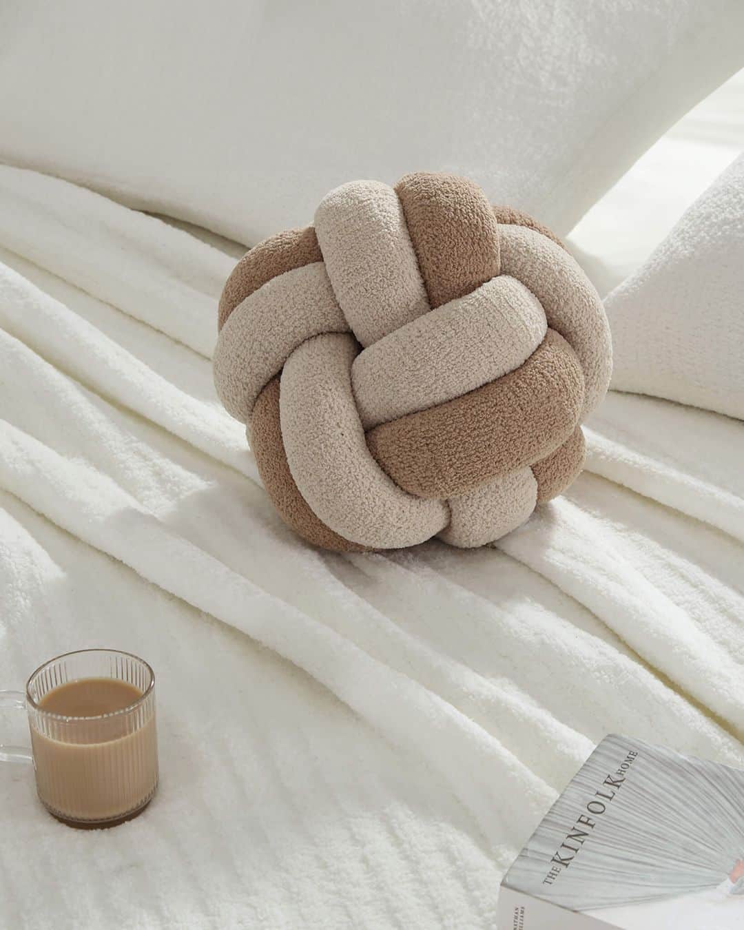 A decorative cushion featuring a complex, spherical knot design made from two intertwined tubular fa… — 3D model
