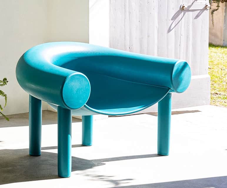 A modern, minimalist lounge chair in a vibrant teal color, featuring a U-shaped backrest and integra… — 3D model
