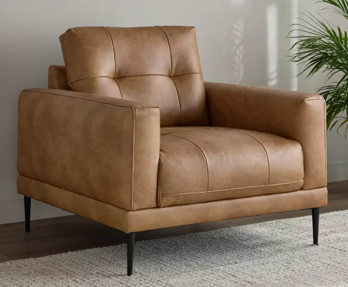 A contemporary armchair upholstered in tan leather, featuring a boxy silhouette, square track arms,… — 3D model