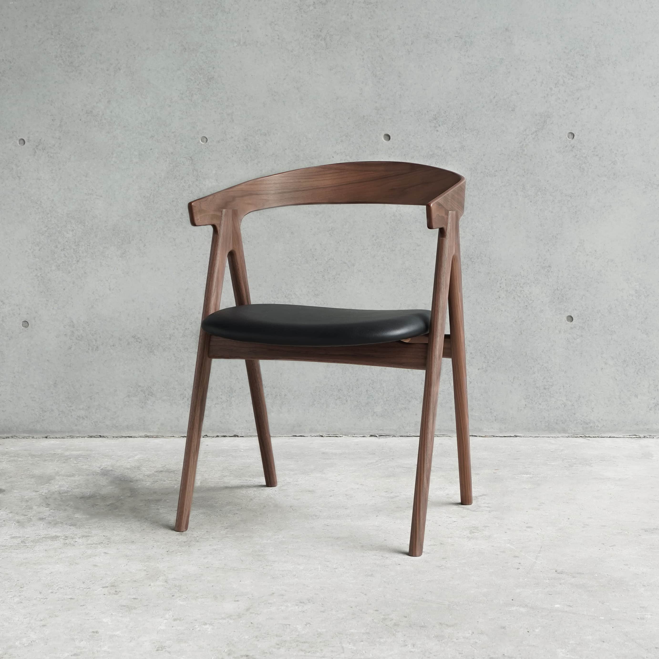 A modern dining armchair constructed from dark walnut wood, featuring a gracefully curved backrest t… — 3D model