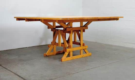 A wooden dining table with a rectangular, dual-sectioned tabletop and a distinct trestle-style base.… — free BLEND 3D model