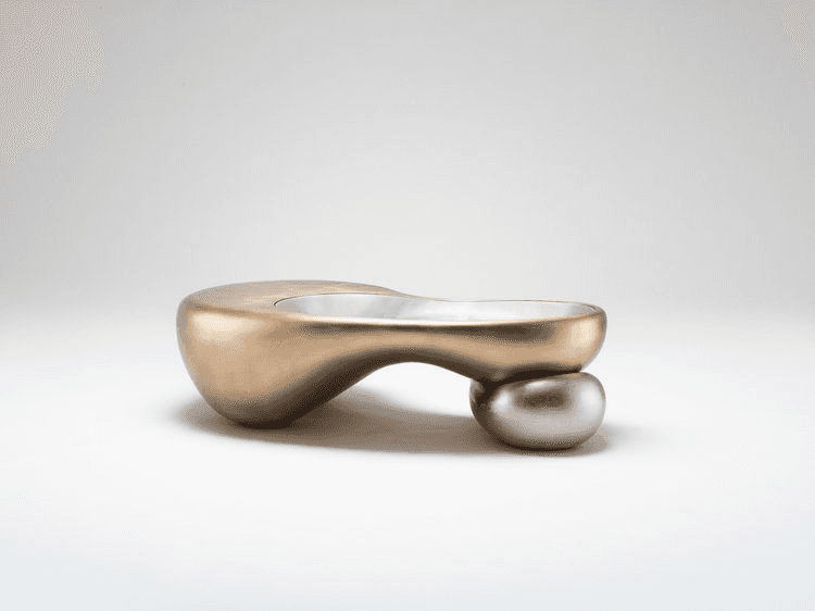 A contemporary coffee table with an organic, sculptural form. It features a fluid, elongated top tha… — 3D model