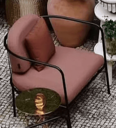 A modern lounge armchair featuring a minimalist black tubular metal frame, soft pink fabric upholste… — 3D model