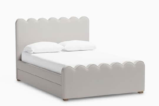 A bed frame with a scalloped headboard and footboard, upholstered in a light gray fabric. The frame… — 3D model