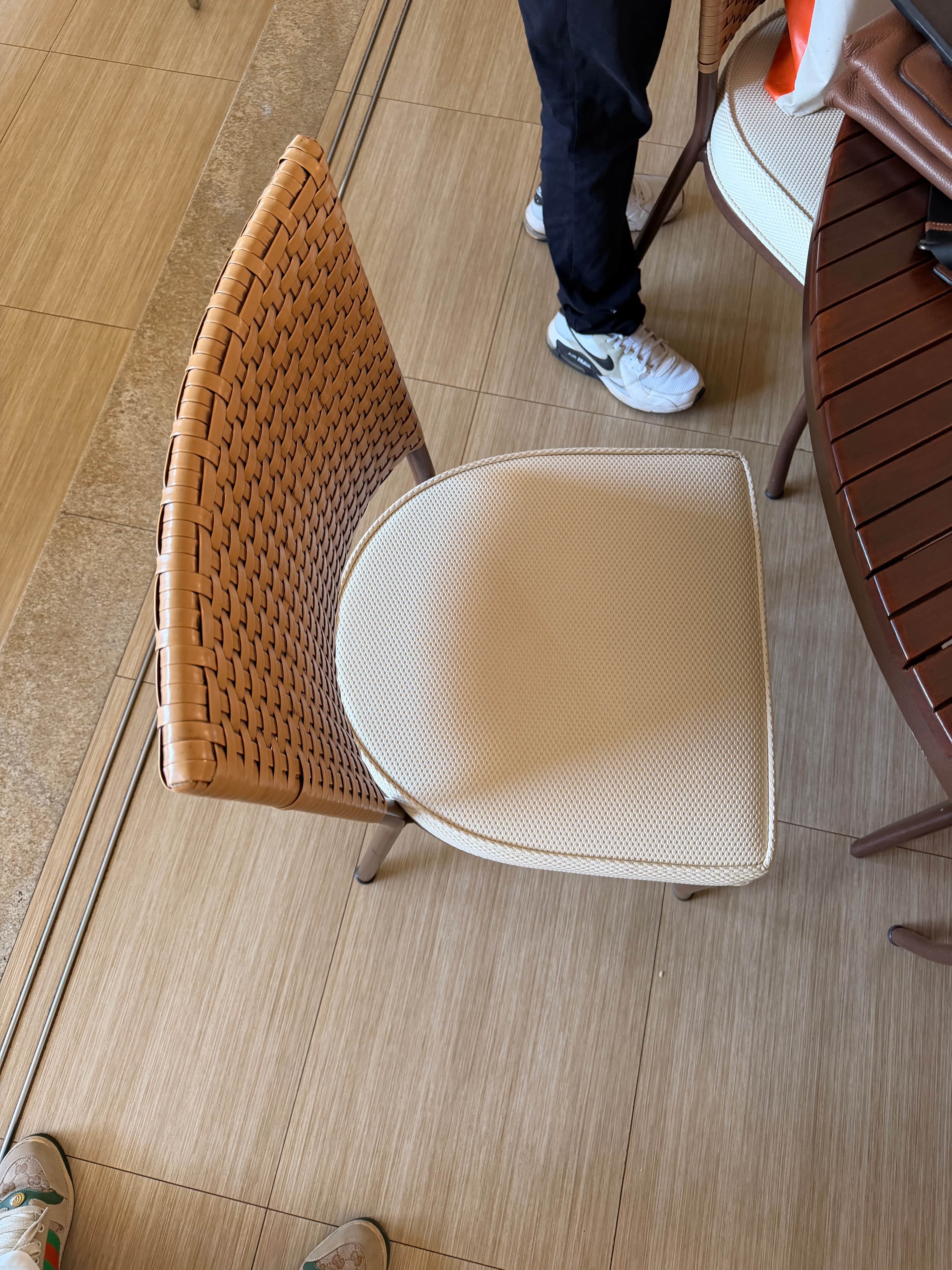 An armless dining chair featuring a curved, woven rattan backrest, an upholstered beige seat cushion… — free STL 3D model