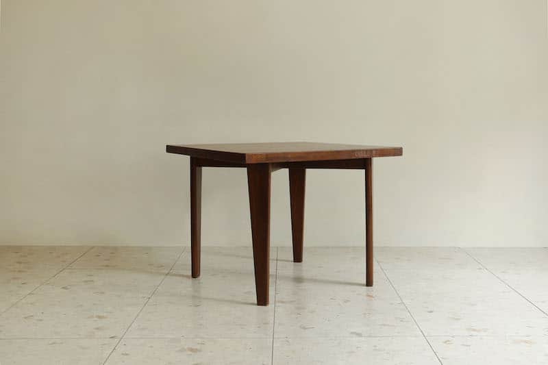 A square wooden table featuring a dark finish and four tapered legs, presented against a light-color… — 3D model